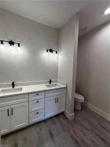 Bathroom with toilet, hardwood / wood-style flooring, and vanity