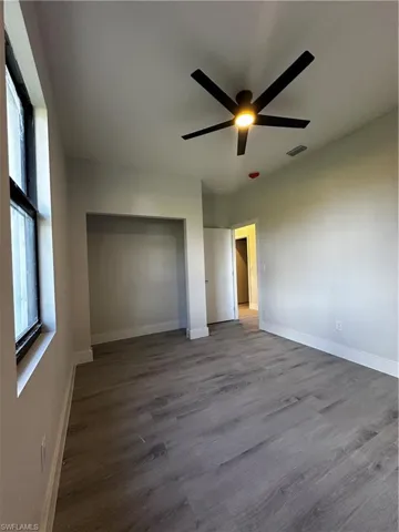 Unfurnished bedroom featuring hardwood / wood-style flooring and ceiling fan