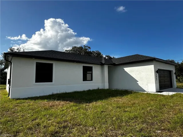 View of side of home featuring a yard and a garage