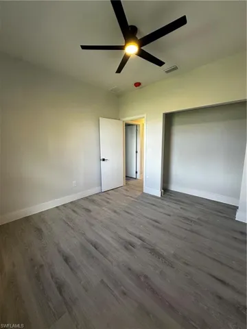 Unfurnished bedroom with wood-type flooring and ceiling fan