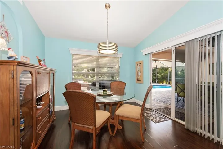 Dining area featuring wood-finish flooring and vaulted ceiling