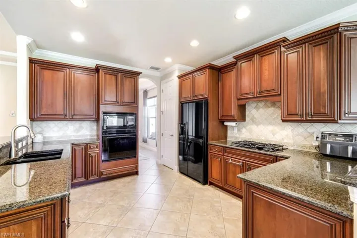 The kitchen features custom wood cabinetry, ample counter space and a breakfast bar - perfect for entertaining.