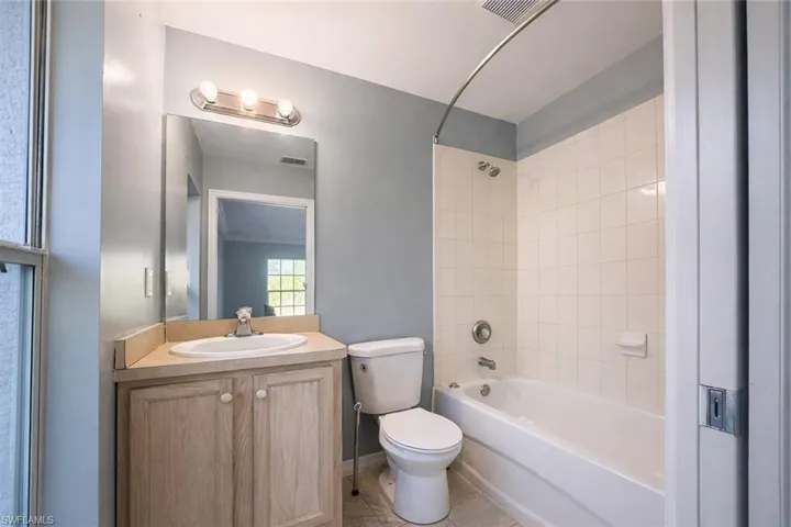 Full bath featuring vanity, shower / tub combination, and light tile patterned flooring