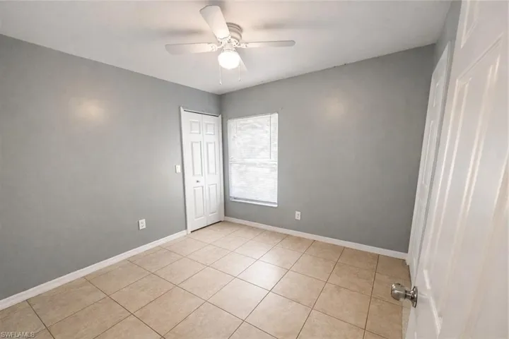 Unfurnished bedroom featuring ceiling fan, a closet, and light tile patterned flooring