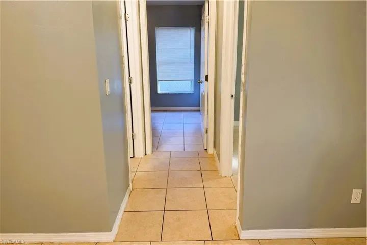Corridor with baseboards and light tile patterned floors