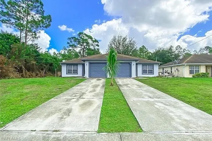 Ranch-style home with a front lawn, concrete driveway, a garage, and stucco siding