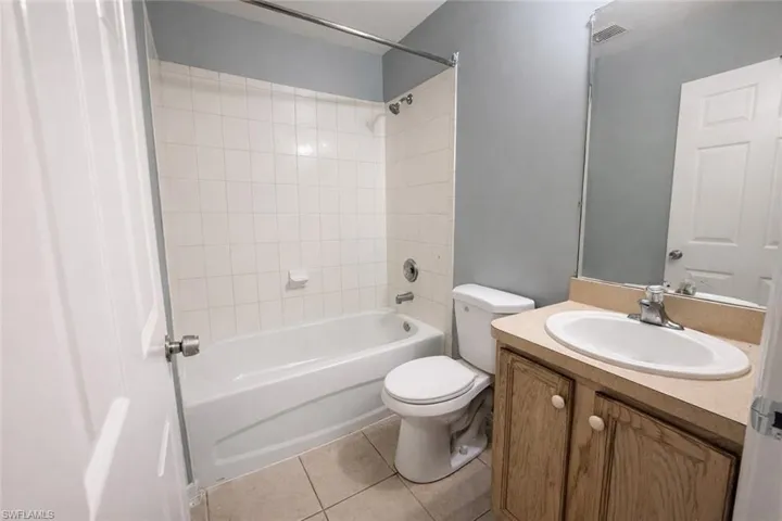 Full bath featuring vanity, shower / tub combination, and light tile patterned flooring