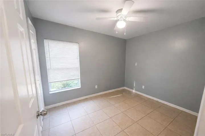 Unfurnished room with ceiling fan and light tile patterned floors