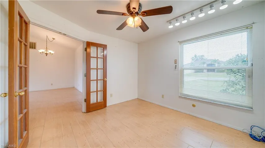 This room located at the front of the home with French doors can be a bedroom or office/study.  It has tile flooring  and a ceiling fan.