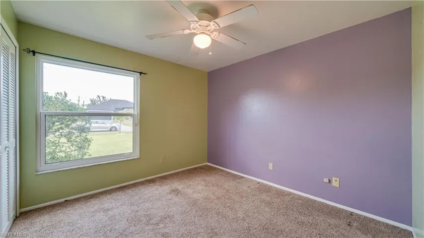 Guest bedroom with carpet and ceiling fan.