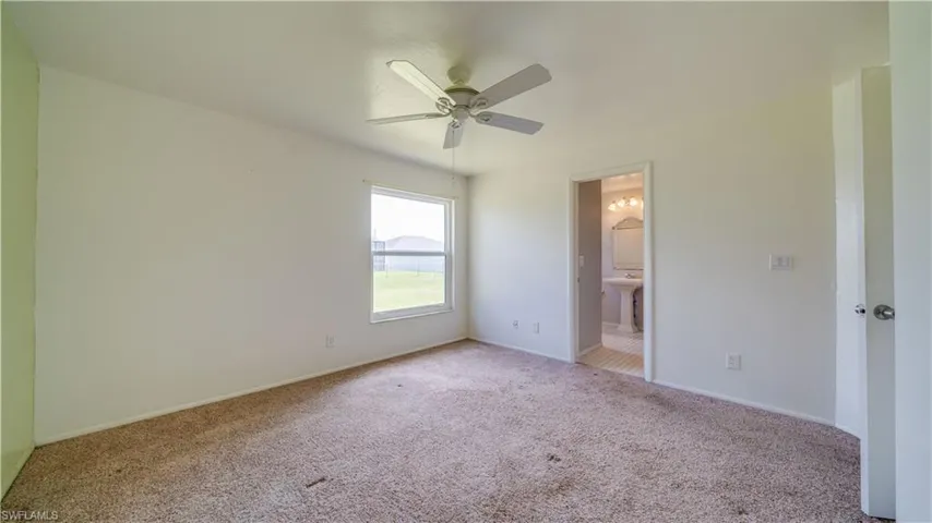 Master bedroom with carpet and a ceiling fan.