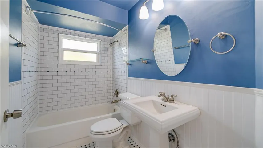 Guest bathroom with tile floor and tub/shower.