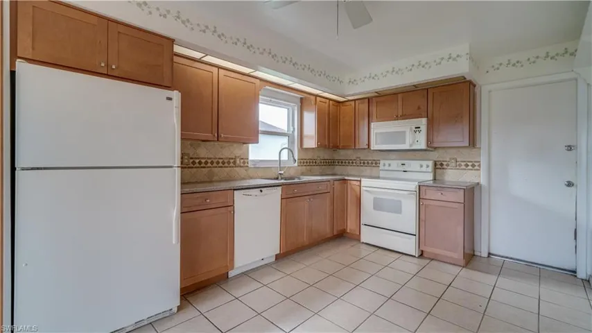 The eat-in kitchen has all wood cabinets, granite counters and tile flooring.