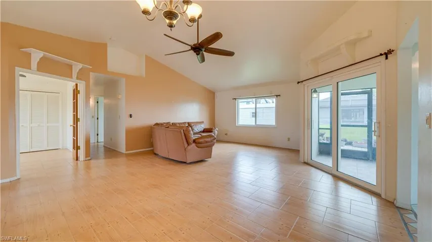 Great room with cathedral ceiling, tile floors, fan and sliders to the lanai.