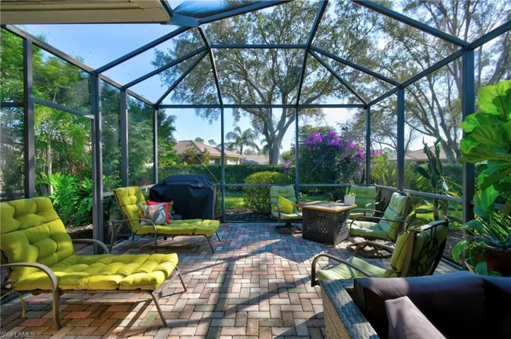 View of patio / terrace featuring area for grilling, glass enclosure, and a fire pit