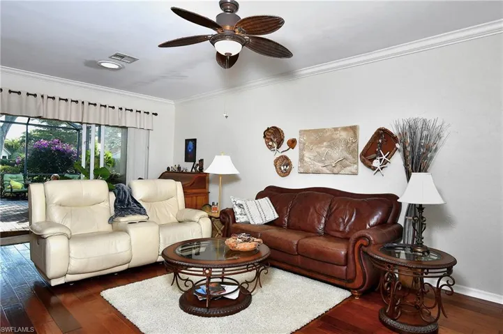 Living room featuring crown molding, ceiling fan, and dark hardwood / wood-style flooring