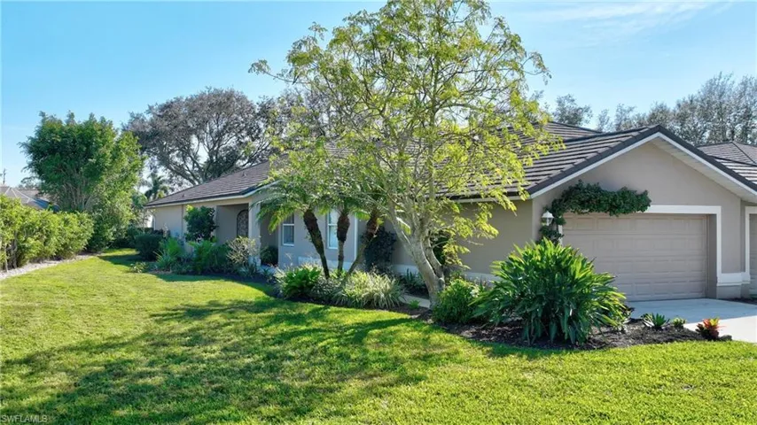 View of front of property featuring a garage and a front lawn