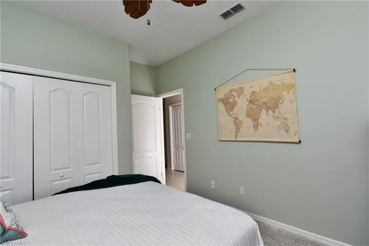Bedroom featuring ceiling fan, light carpet, and a closet