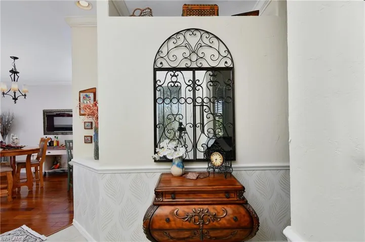 Interior details with hardwood / wood-style flooring, ornamental molding, and an inviting chandelier