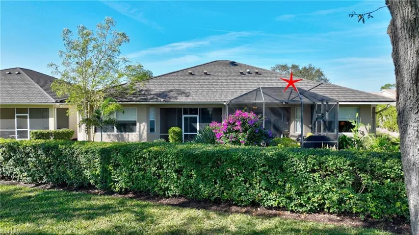View of front of home featuring a front yard and glass enclosure