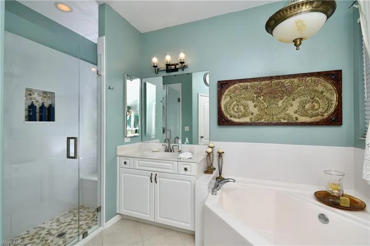 Bathroom featuring vanity, independent shower and bath, and tile patterned flooring