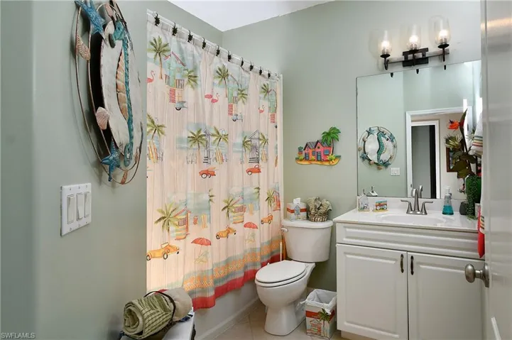 Full bathroom with vanity, tile patterned flooring, toilet, and shower / bath combo