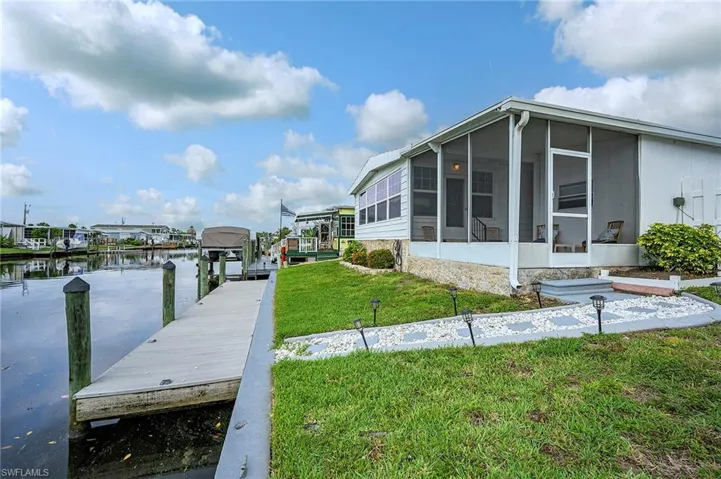 View of dock with a water view and a yard