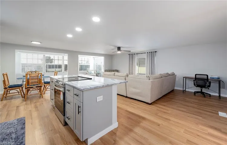 Kitchen with ceiling fan, light hardwood / wood-style flooring, stainless steel range with electric cooktop, black electric cooktop, and gray cabinets