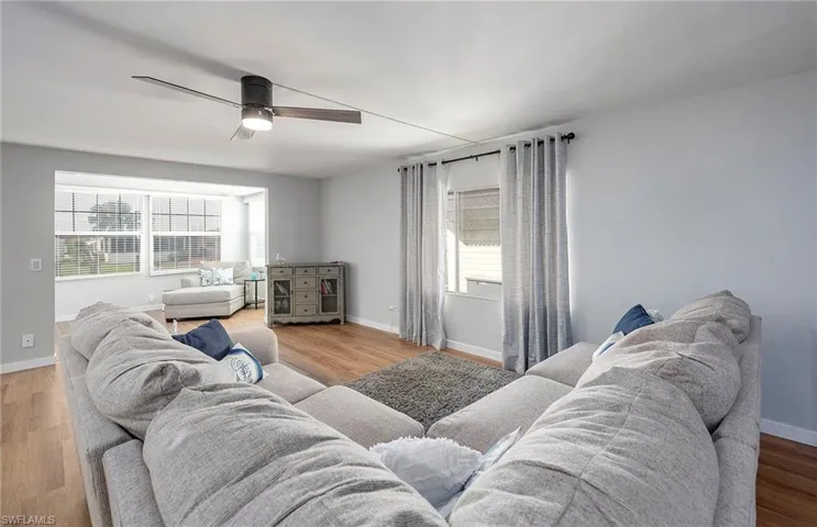 Living room with a healthy amount of sunlight, ceiling fan, and hardwood / wood-style flooring