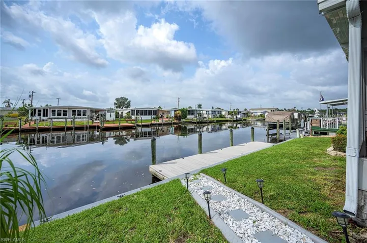 Dock area with a water view and a lawn