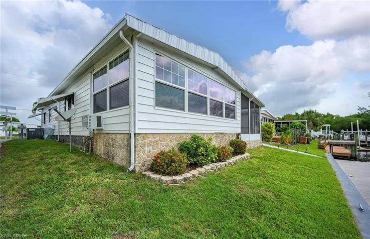 View of side of property featuring a sunroom and a lawn