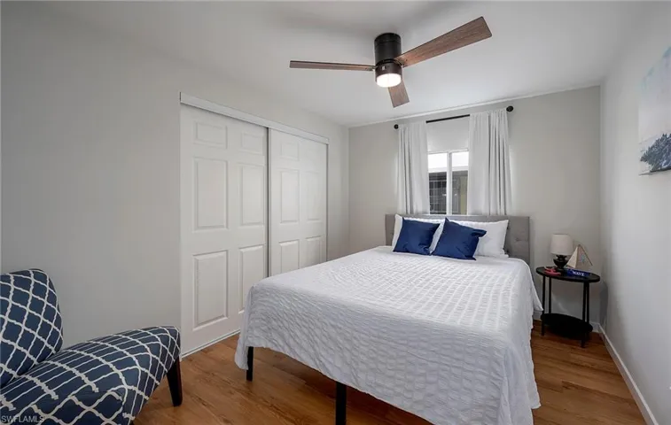 Bedroom with a closet, wood-type flooring, and ceiling fan