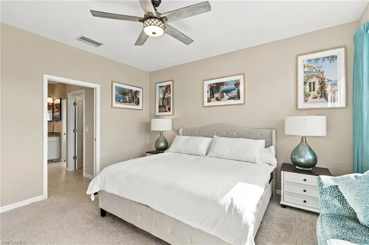 Neutral-toned room featuring wall-to-wall carpeting and a multi-blade ceiling fan with an integrated light fixture