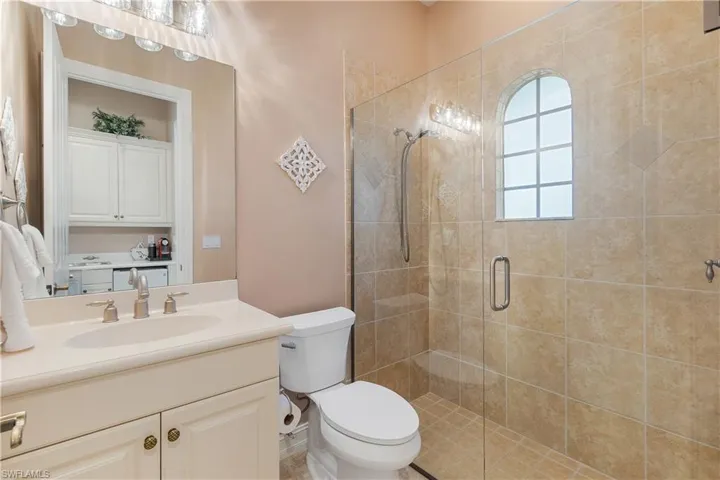 Bathroom with vanity, toilet, and an enclosed shower