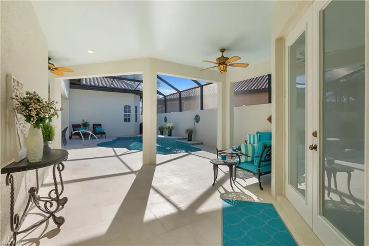 View of patio with ceiling fan, a fenced in pool, and glass enclosure