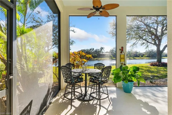 Sunroom with ceiling fan and a water view
