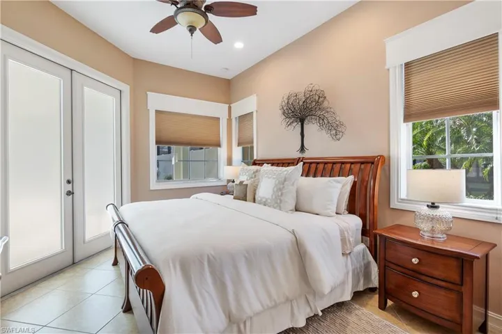 Tiled bedroom featuring access to outside and ceiling fan