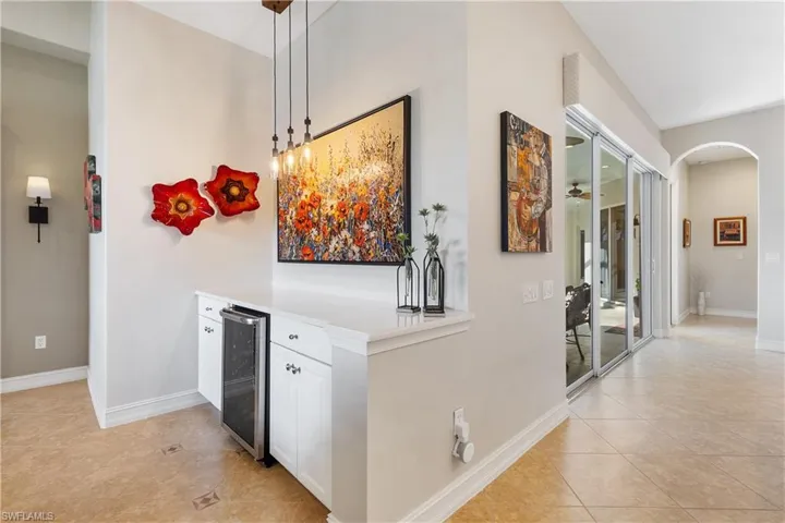 Corridor with wine cooler and light tile patterned floors