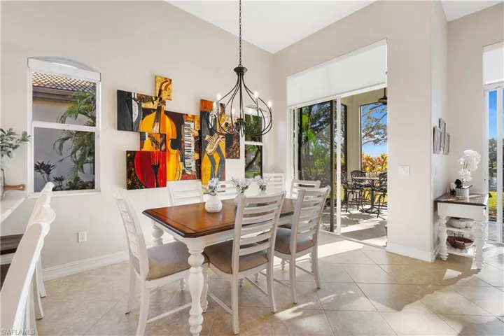 Dining area featuring light tile patterned floors, a chandelier, and a high ceiling