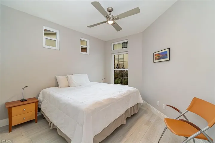 Guest Bedroom with ceiling fan, multiple windows, and light tile flooring