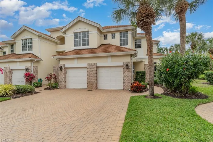 View of front of property with a garage and a front lawn