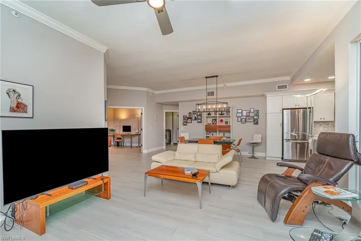 Living room featuring crown molding and ceiling fan
