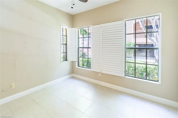 Spare room featuring ceiling fan and light tile patterned floors
