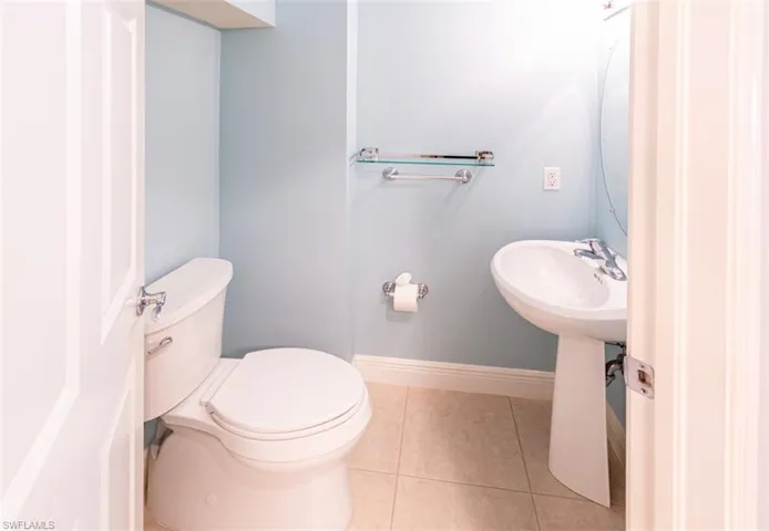 Half bathroom featuring tile patterned floors and toilet