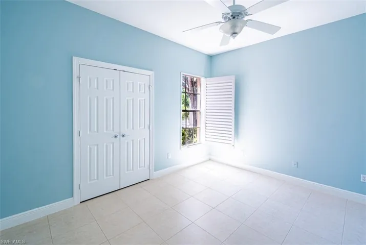 Unfurnished bedroom featuring light tile patterned flooring, a closet, and ceiling fan
