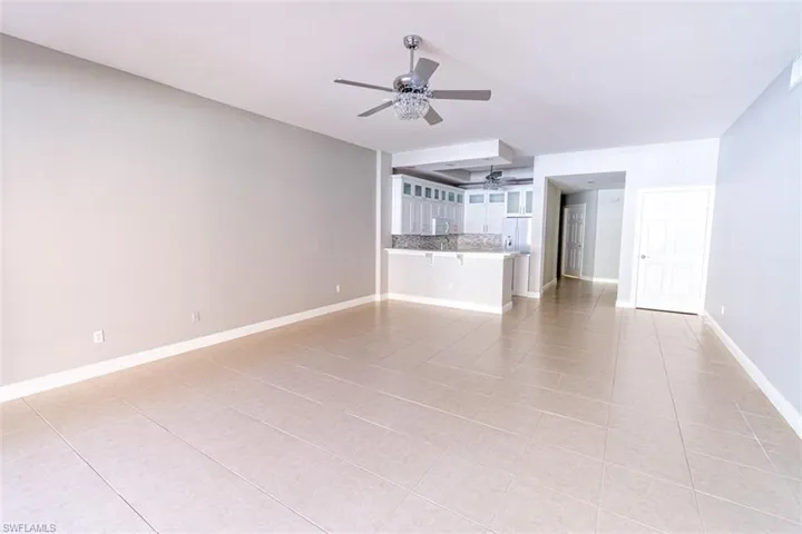 Unfurnished living room with light tile patterned flooring and ceiling fan
