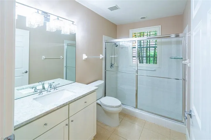Bathroom featuring vanity, a shower stall, and light tile patterned floors