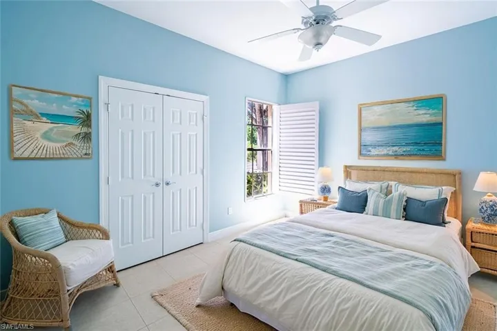 Tiled bedroom featuring a ceiling fan and a closet
