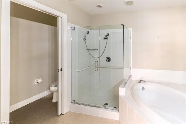 Bathroom with a stall shower, a garden tub, and tile patterned flooring