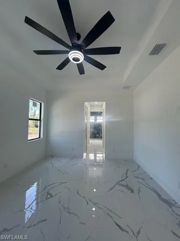 Unfurnished room with light marble finish floors, a tray ceiling, and recessed lighting